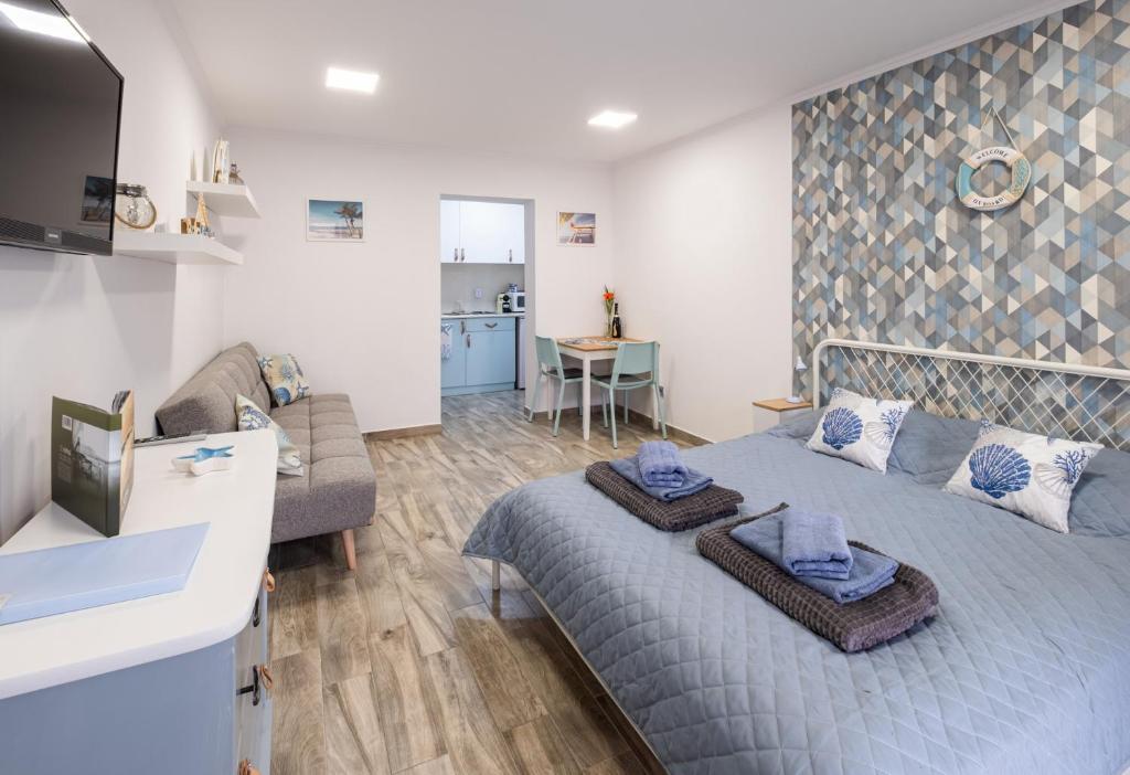 a living room with a bed and a couch at Mirabella apartman in Csopak