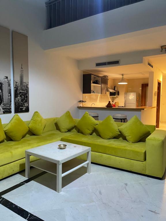 a living room with a green couch and a table at Saada in Tangier