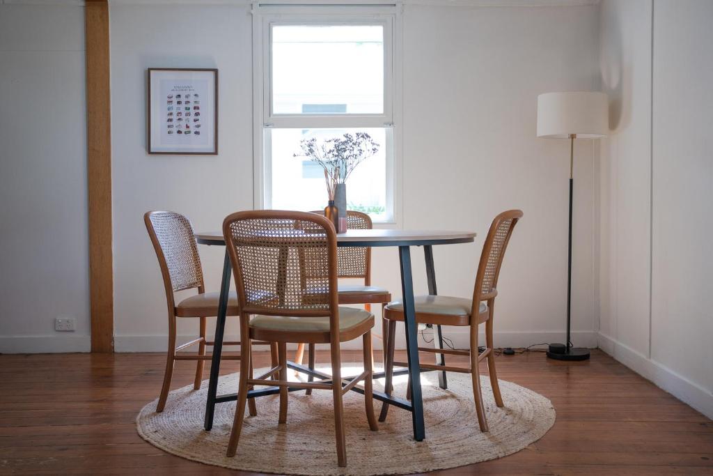 a dining room table with chairs and a window at Gunuma Shack in Mount Beauty