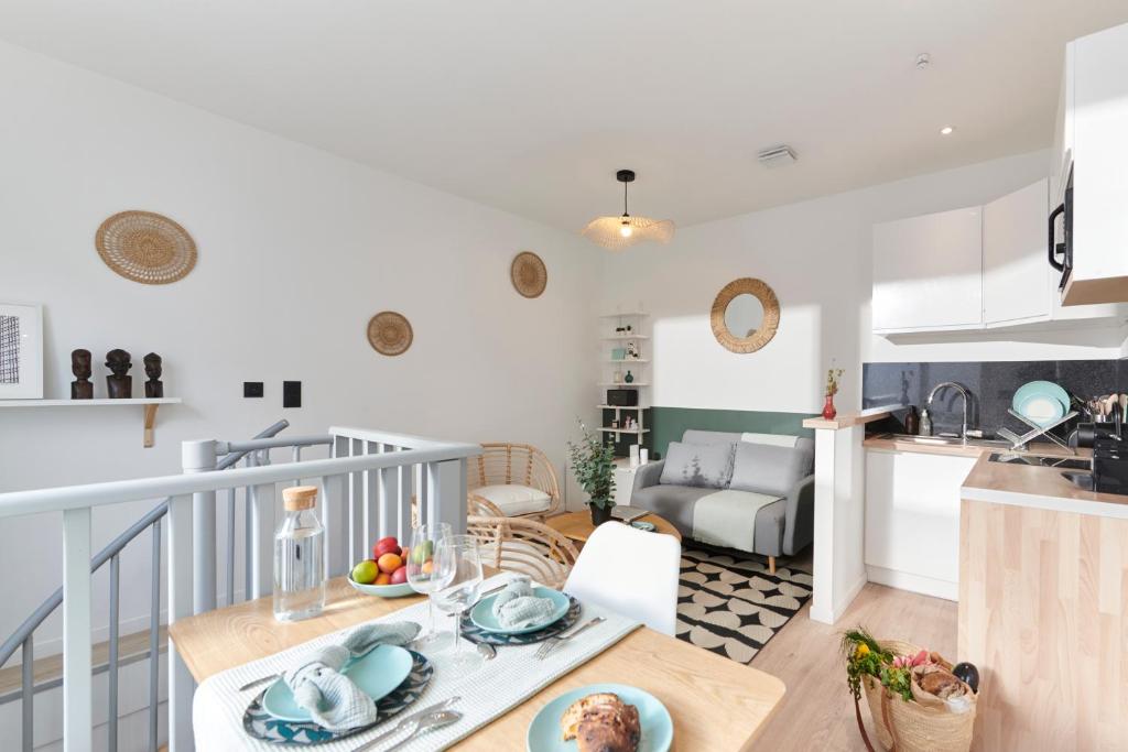 a kitchen and living room with a table and a kitchen and a living room at Charmant T2 - 2min de Lille in Ronchin
