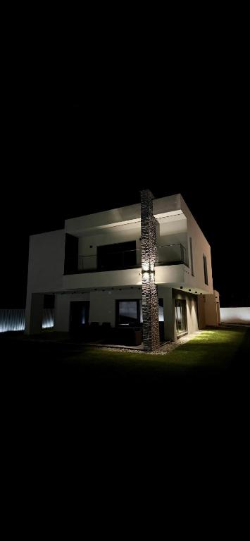 ein großes weißes Gebäude mit einer Lampe darauf bei Nacht in der Unterkunft ASPECT House in Caransebeş