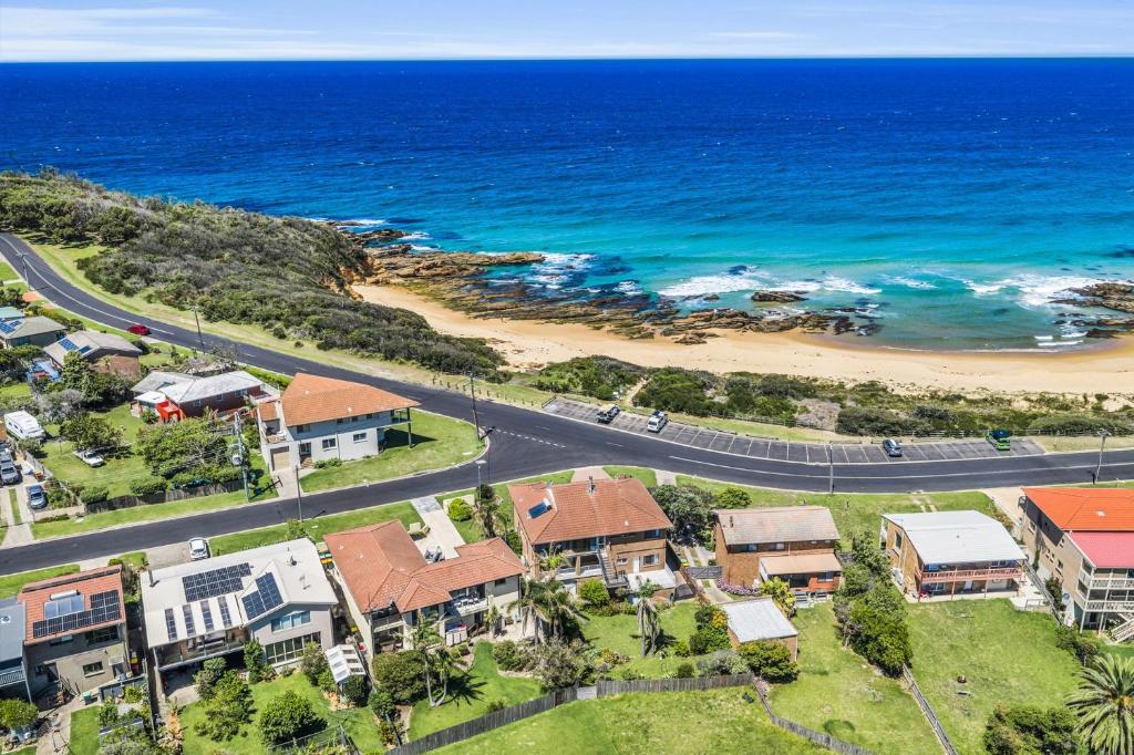 an aerial view of a beach with houses and a road at Fishers - Scenic Drive 35 in Bermagui