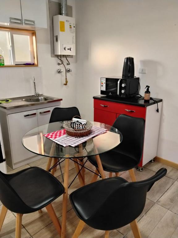 a kitchen with a table and chairs in a kitchen at Cabañas Haru Puerto Natales in Puerto Natales