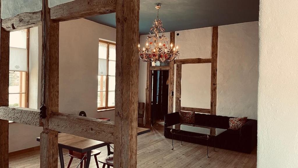 a living room with a chandelier and a couch at Der Pfeil - Gutshaus Bückling in Rambin
