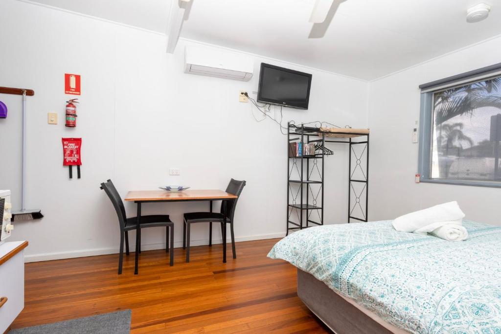 a bedroom with a bed and a desk and a table at Koala Lodge Studio 2 in Iluka