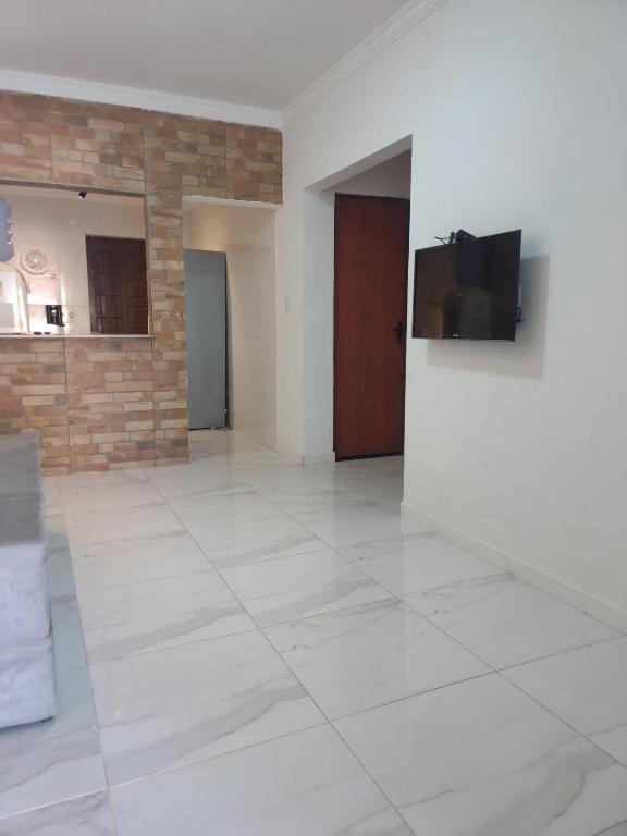 an empty room with a television on a wall at Espaço Nossa Casa, Piscina e churrasqueira Privativas in Paulista