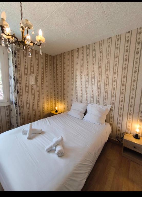 a bedroom with a large white bed with two towels on it at Maison Atypique 5 chambres in Le Mans