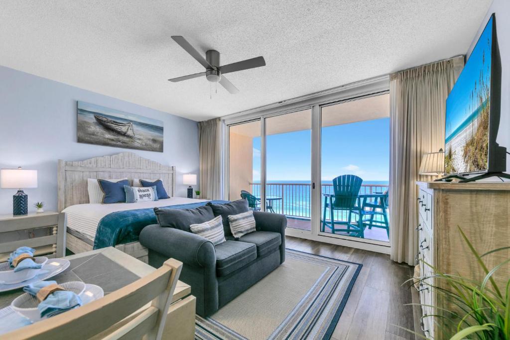 a bedroom with a bed and a living room at Beachfront Studio #909 at Majestic in Panama City Beach