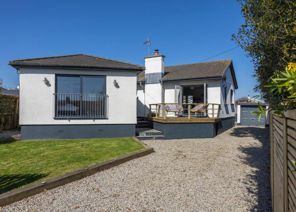 a white house with a fence in front of it at 38 Venn Park in Stoke Fleming