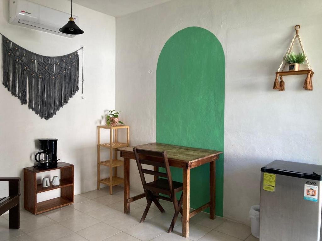 a room with a table and a green wall at GalHaus in Bacalar
