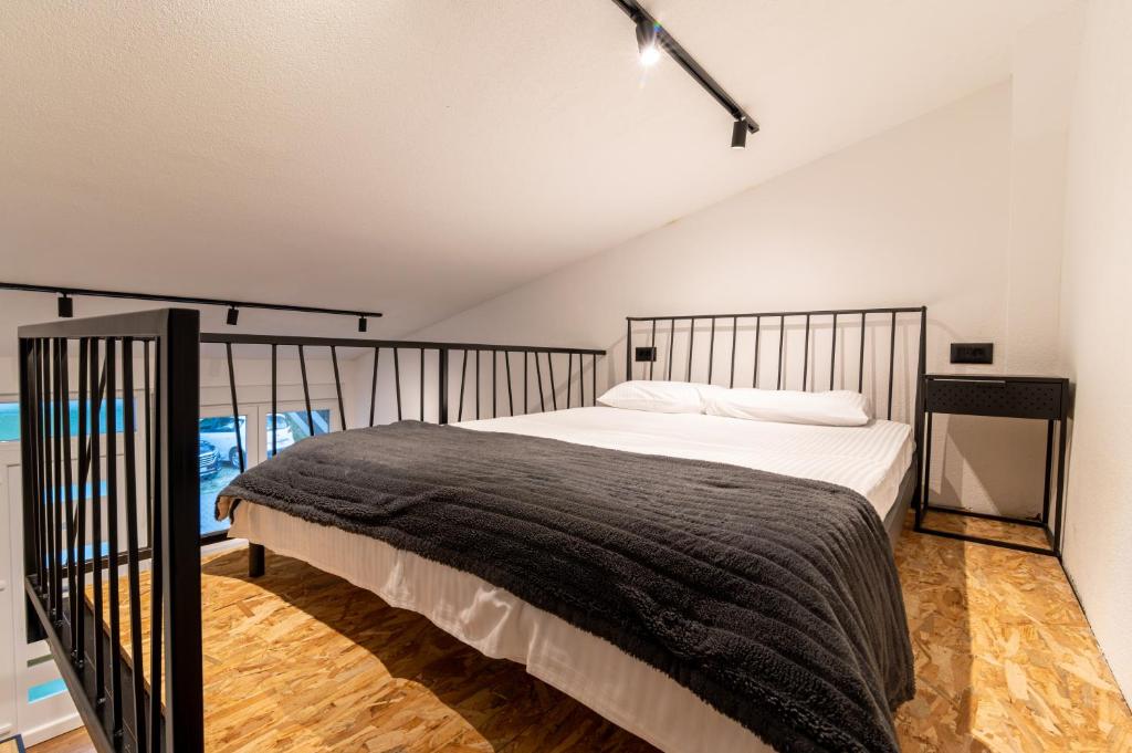 a bedroom with a large bed with a black blanket at Pink bird apartments and FREE PARKING in Virpazar