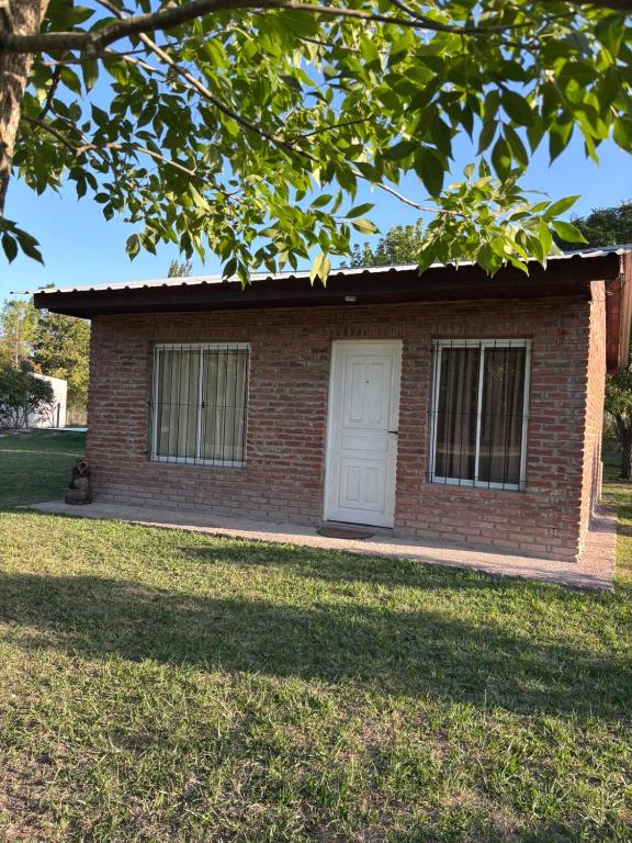 a small brick house with a white door at Carpe diem CyC in Chascomús