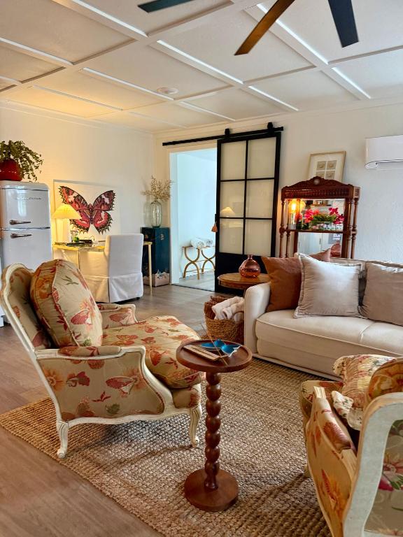 a living room with a couch and chairs and a table at The Wing - luxurious king suite tiny studio home! in Eureka Springs