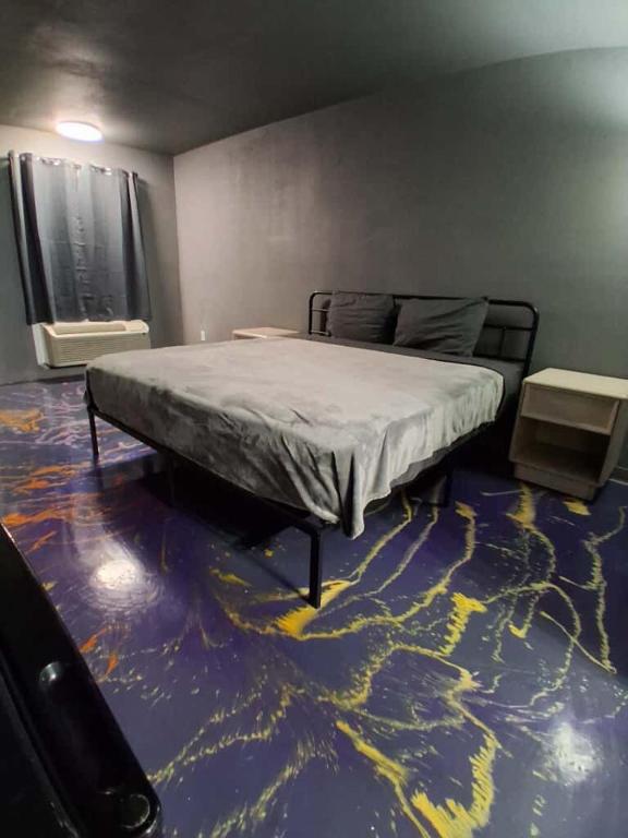 a bedroom with a bed on a blue floor at King Bed Hotel Room 255 in Jackson