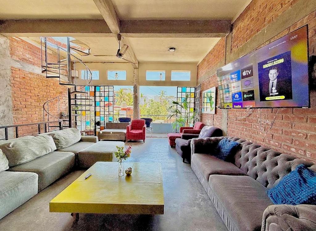 a living room with couches and a brick wall at Casa Maruja CoLiving Walk to Beach in Puerto Vallarta