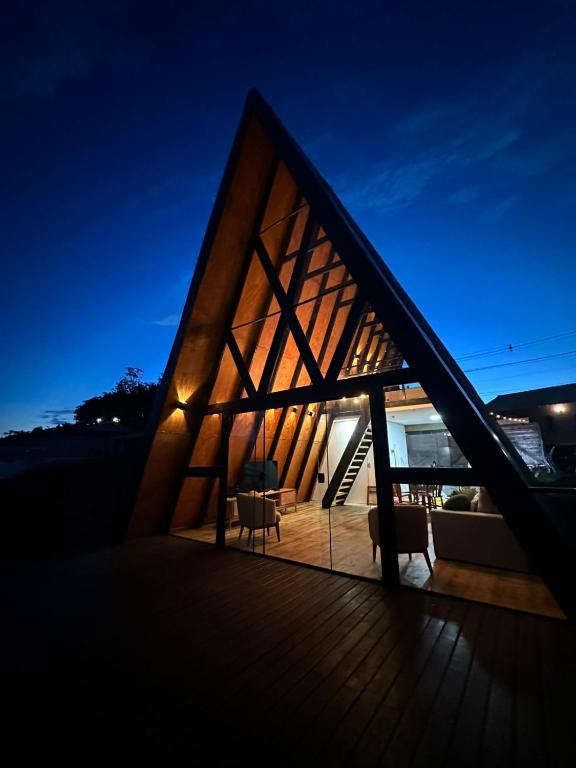 a small house with a triangular roof at night at Chalé Aurora - Sebollas - Paraíba do Sul in Paraíba do Sul