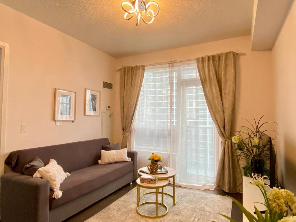 a living room with a couch and a window at Luxurious Condo Apartment with Direct Subway Access in Toronto