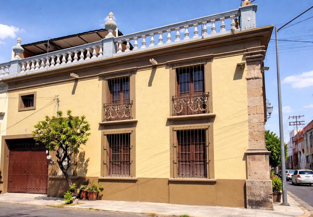 a yellow house with a balcony on top of it at Casa Brusodia in Guadalajara