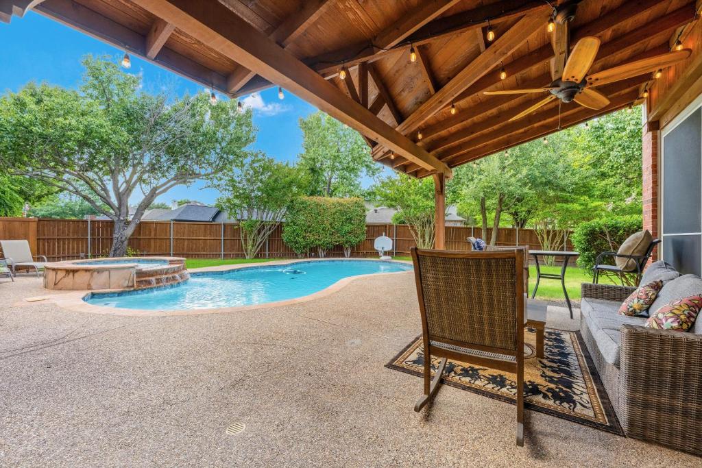 a patio with a pool and a wooden pergola at Meadow Park in Allen