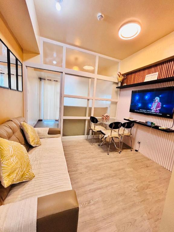 a large living room with a couch and a tv at RR 21 Milan Residenze Fairview in Manila