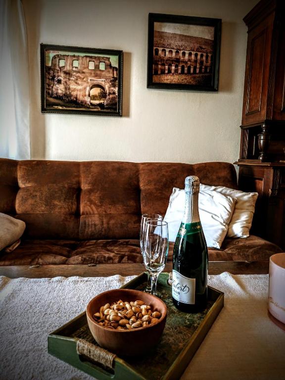 a bottle of wine and a glass on a table in a living room at Baboško in Rimavská Sobota