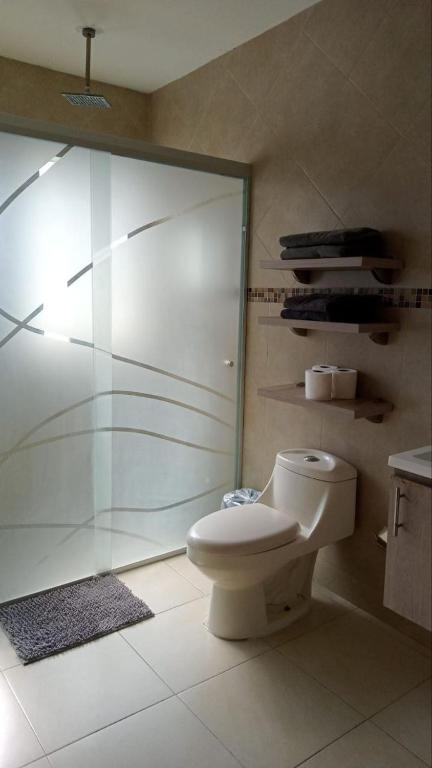 a bathroom with a toilet and a glass shower at Practico Mini Departamento ideal para estancias largas in San Luis Potosí