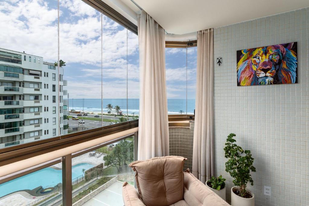 a room with a large window with a view of the ocean at Caribe Carioca in Rio de Janeiro