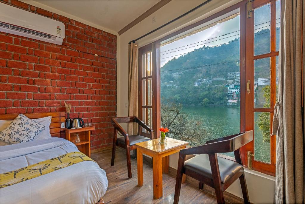 a bedroom with a bed and a window with a view at By the Lake Boho Bhimtal in Bhīm Tāl
