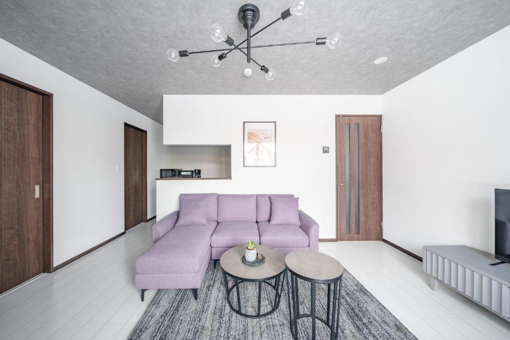 a living room with a purple couch and a table at Hills Niseko 106 in Niseko