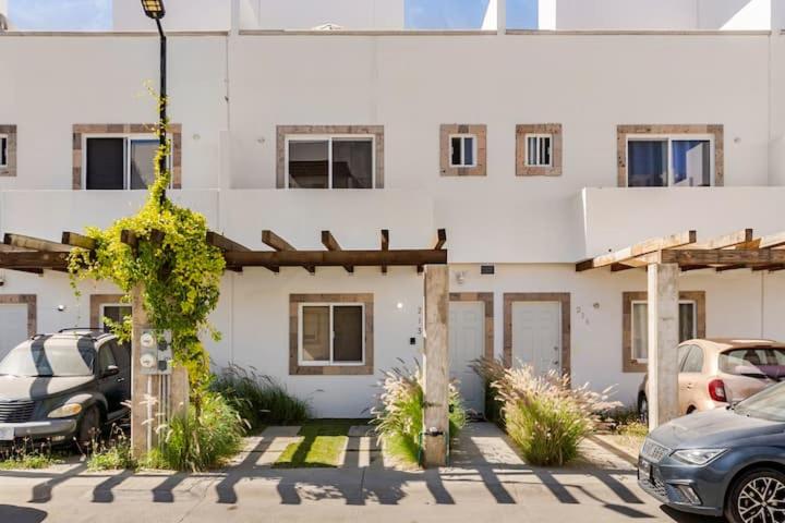 a white building with cars parked in front of it at SHINYADO Casa de Huéspedes Cabo San Lucas in Cabo San Lucas