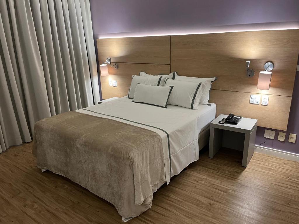 a bedroom with a large bed with white pillows at Stay Santos 2301 in Santos