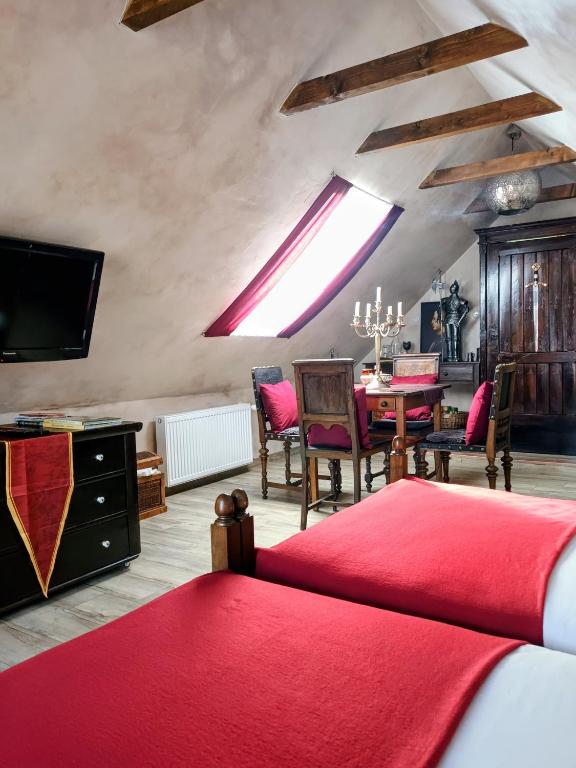 a bedroom with a dining room table with a red blanket at Hraško in Rimavská Sobota