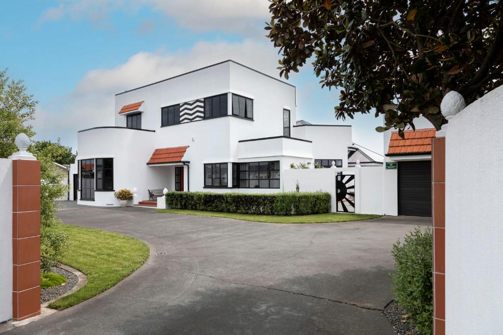 a white house with a driveway at The Deco Retreat in Hawera