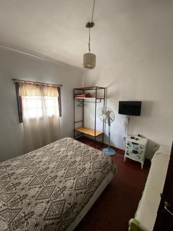 a bedroom with a bed and a window and a fan at Casitadelavid in Capilla del Monte