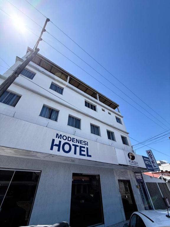 a hotel with a sign on the front of it at Modenesi Hotel in Linhares