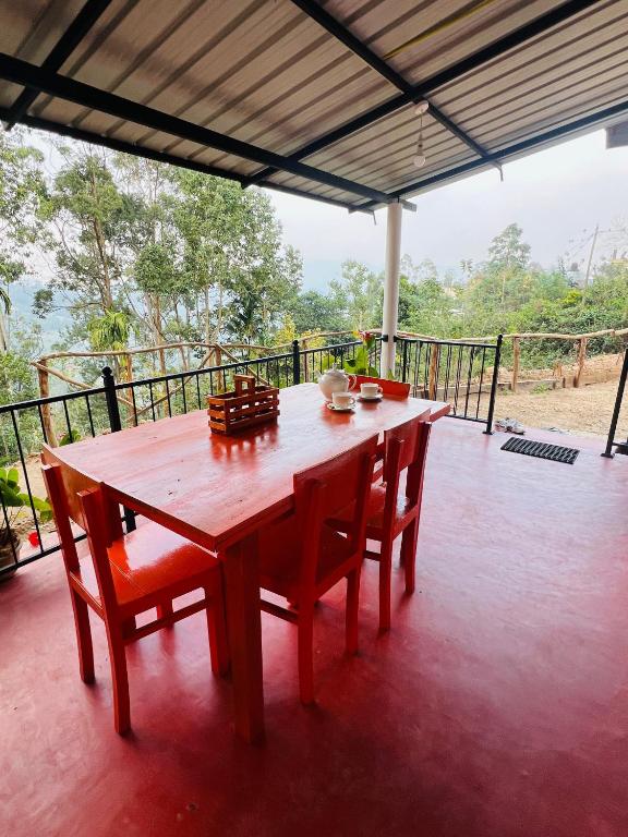 a wooden table and chairs sitting on a porch at Mount View Plaza - Ella Cottage with Mountain &Valley View in Ella