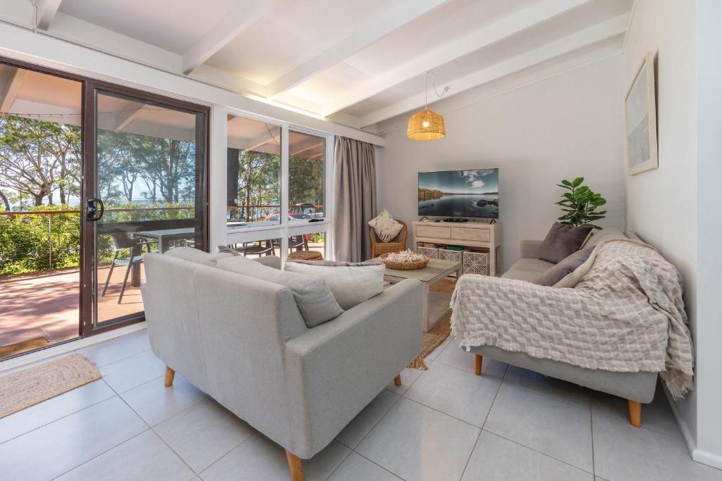 a living room with two couches and a tv at Sandpiper 4 in Smiths Lake