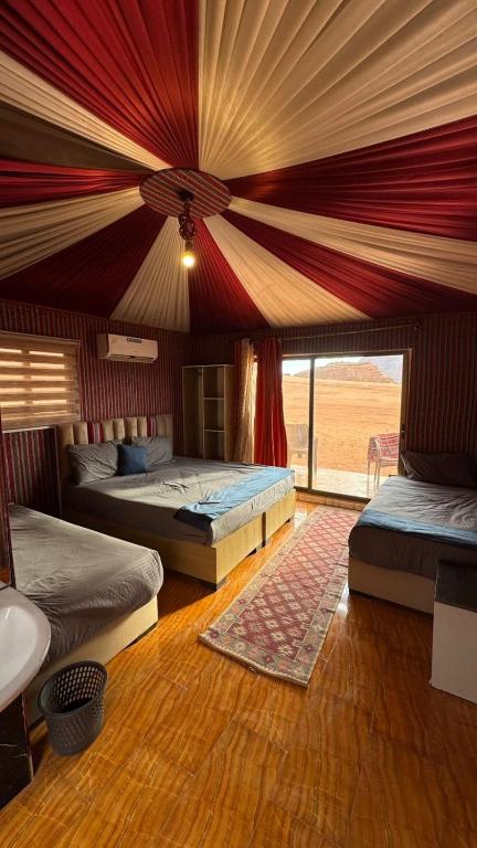 a bedroom with two beds and a large window at elan luxury camp in Disah