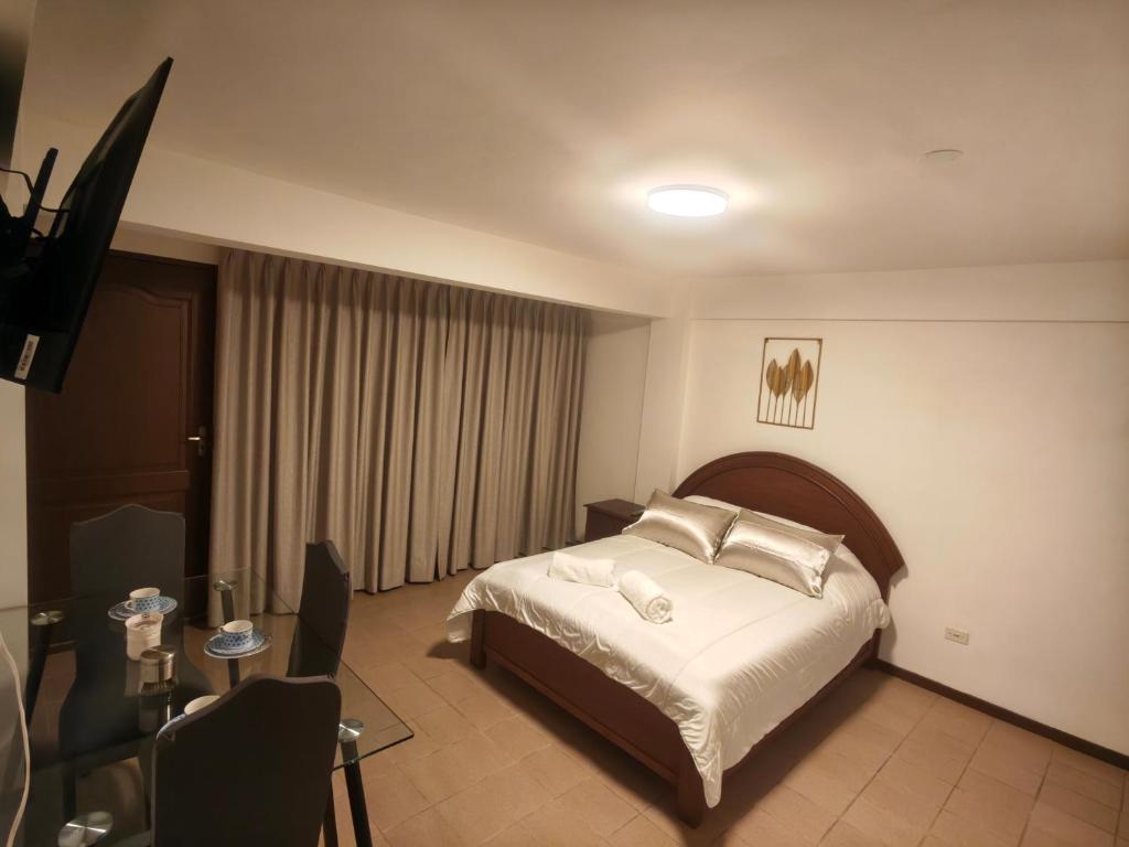 a bedroom with a bed with white sheets and pillows at Cochabamba Mágica - Aniceto Arce - B in Cochabamba