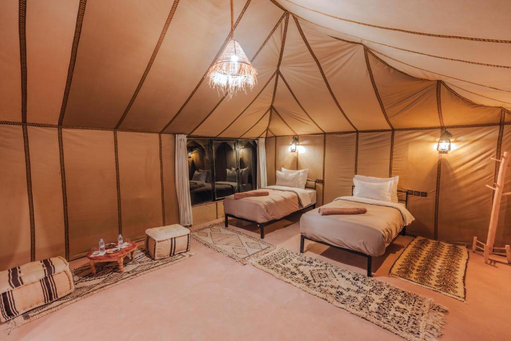 a room with two beds in a tent at Luxury Camp Sahara in Merzouga