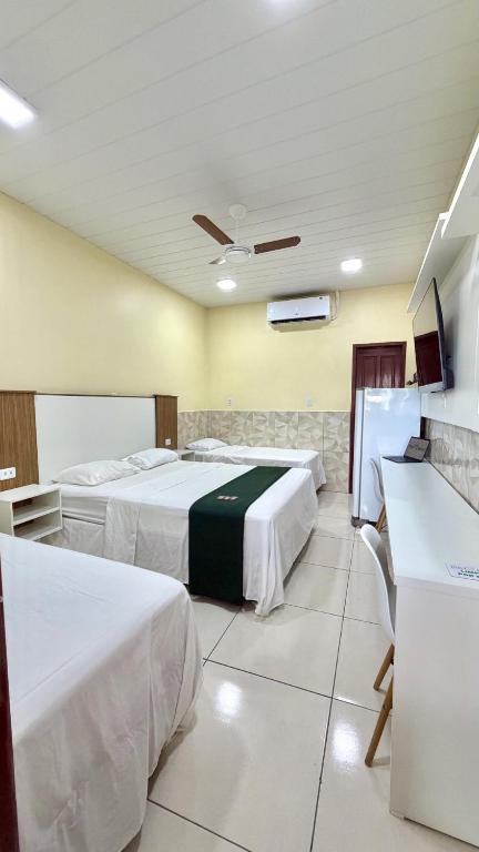 a hotel room with two beds and a flat screen tv at Hotel Maracá in Boa Vista