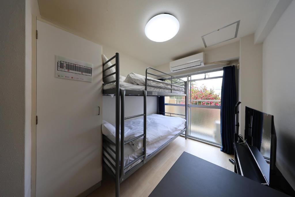 a room with two bunk beds and a window at Tsurumai Nagoya Stay in Nagoya