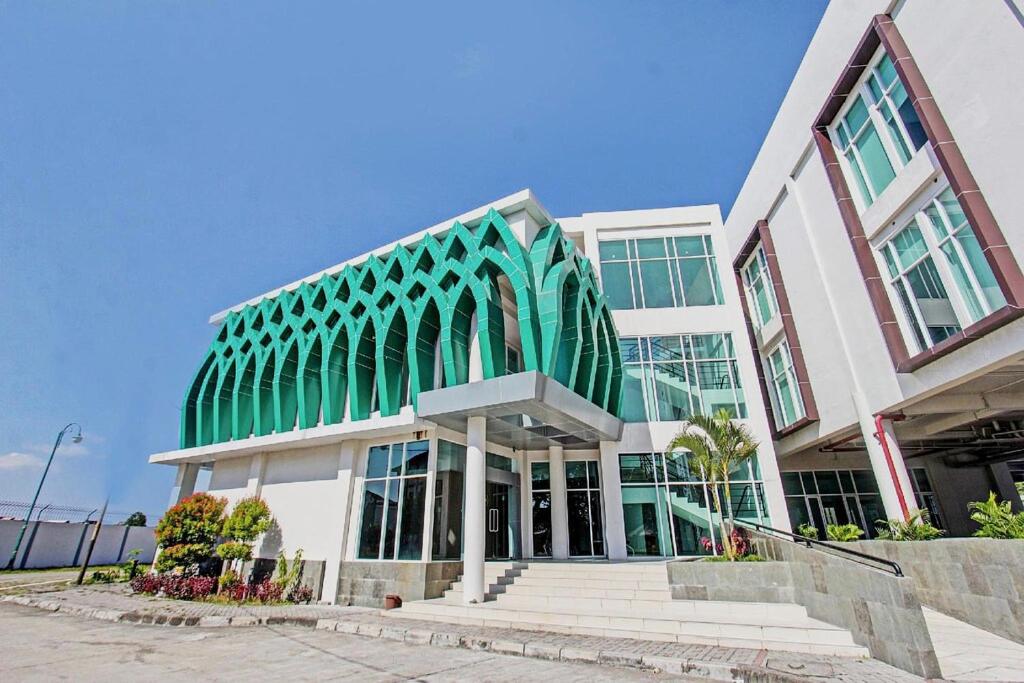 a green and white building with stairs in front of it at Hotel Training Center UIN Mataram in Mataram