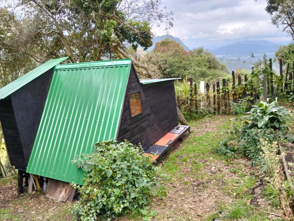 a tiny house with a green roof in a vineyard at Chalet CAJIK Project, tipo Nordico in Cajicá