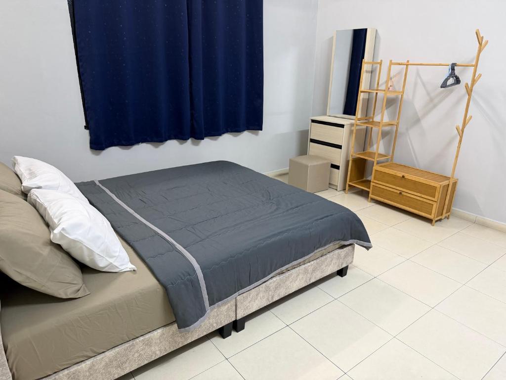 a bedroom with a bed and a blue curtain at Greeny Homestay in Muar