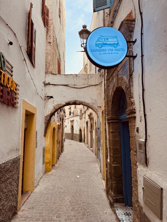 an alley with a sign on the side of a building at essaouira van hostel in Essaouira
