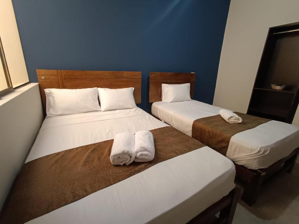 two beds in a room with towels on them at Villa Gabriel Hotel in Piura