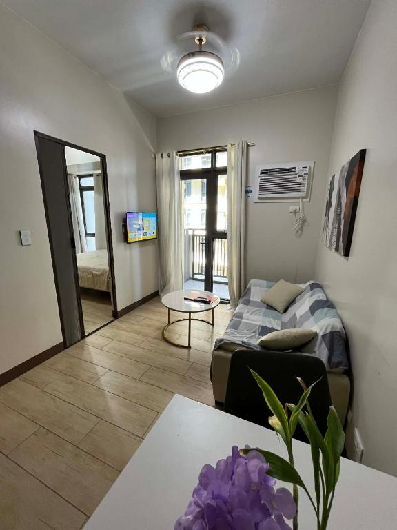 a living room with a couch and a table at GENTRY MANOR fast WiFi,Balcony near Okada,MOA&NAIA 8Q in Manila