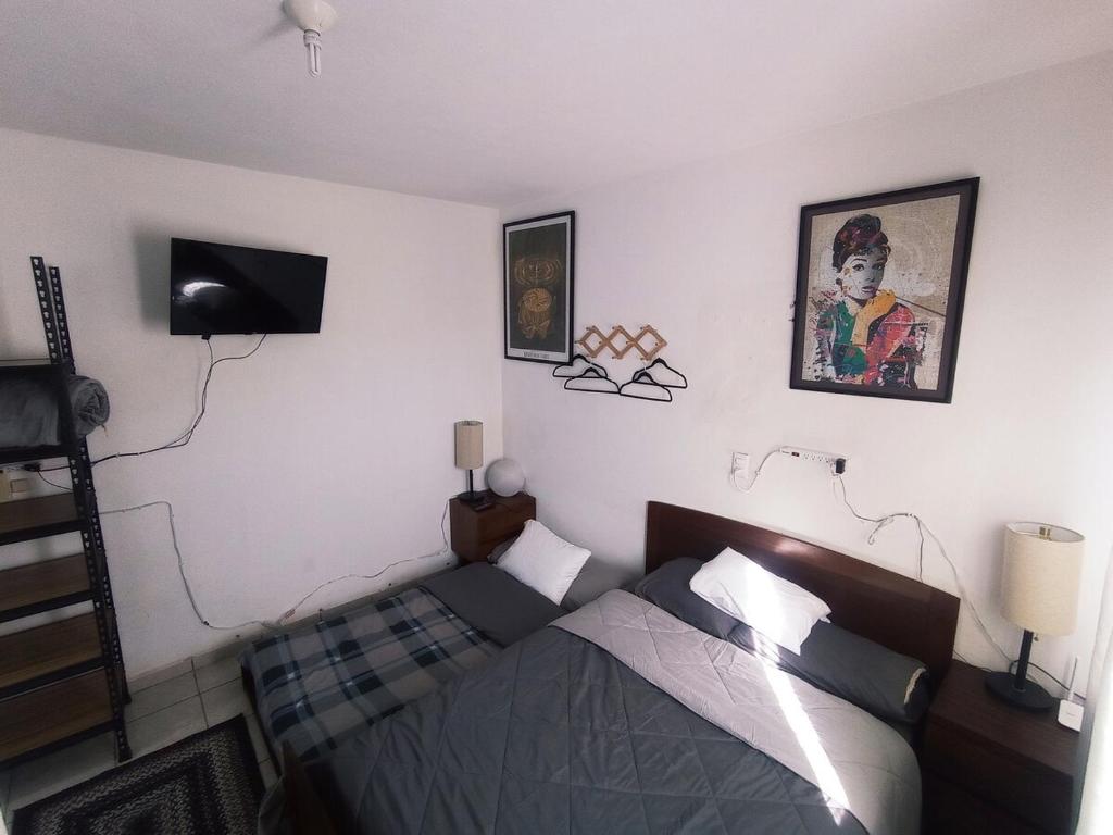 a bedroom with a bed and a tv on the wall at Casa Capuchina in Querétaro