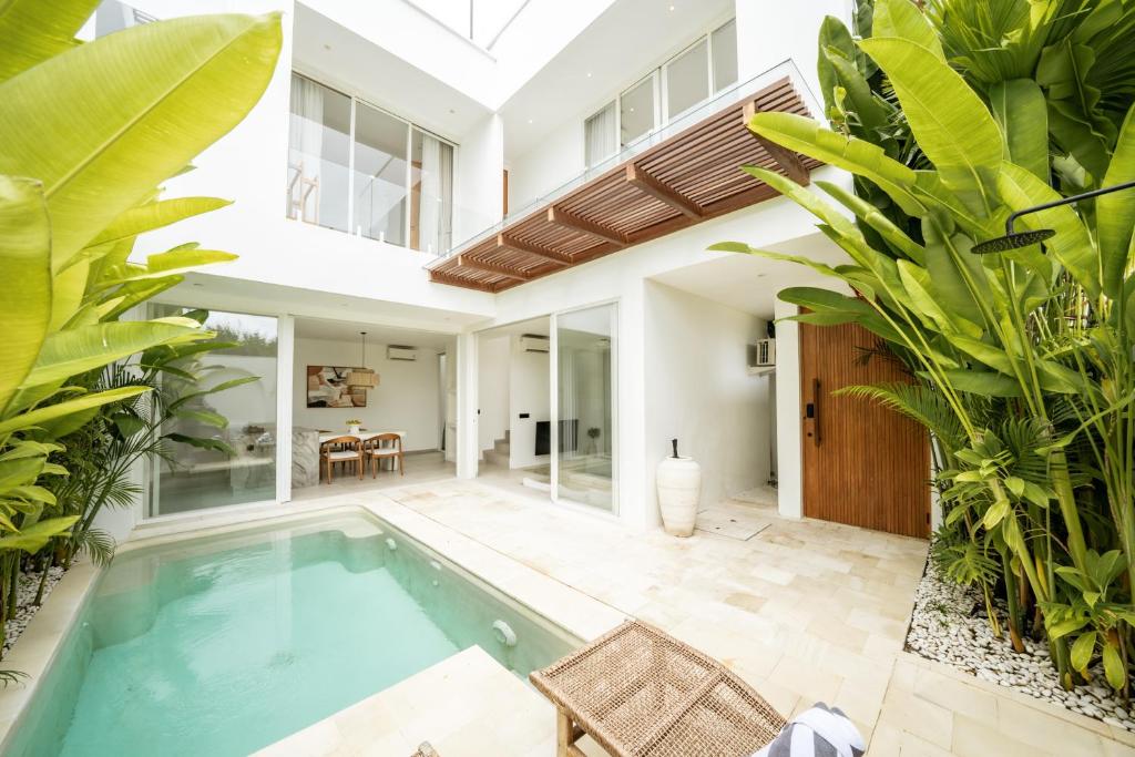 an indoor pool in a house with plants at The Belluoccio Villa Pererenan in Tumbak Bayuh